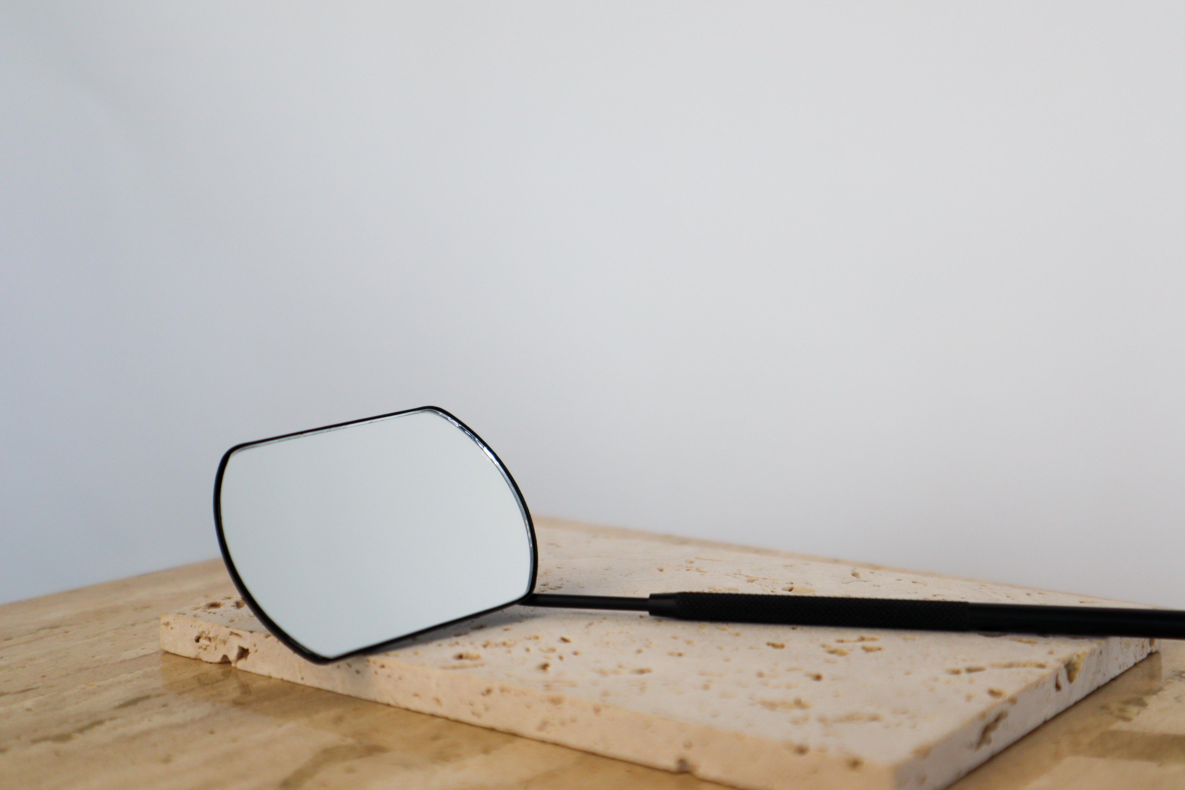 Angled mirror on a wooden surface with a plain background