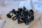 Black glue holder rings on a beige surface with a blurred white background