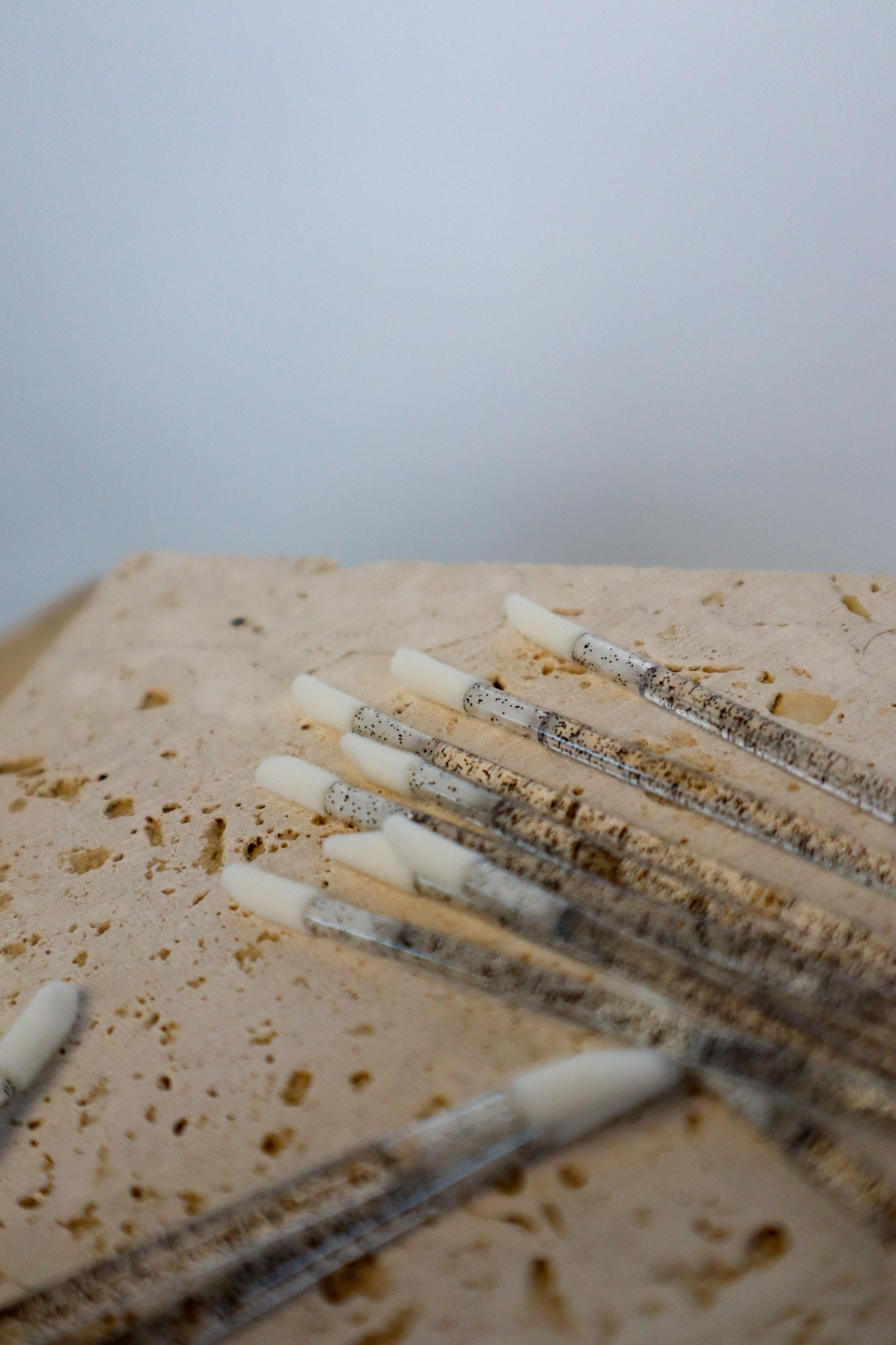 Multiple disposable lip wands on a textured surface