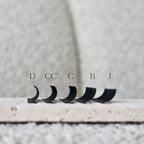 Set of false eyelashes with size labels on a neutral background