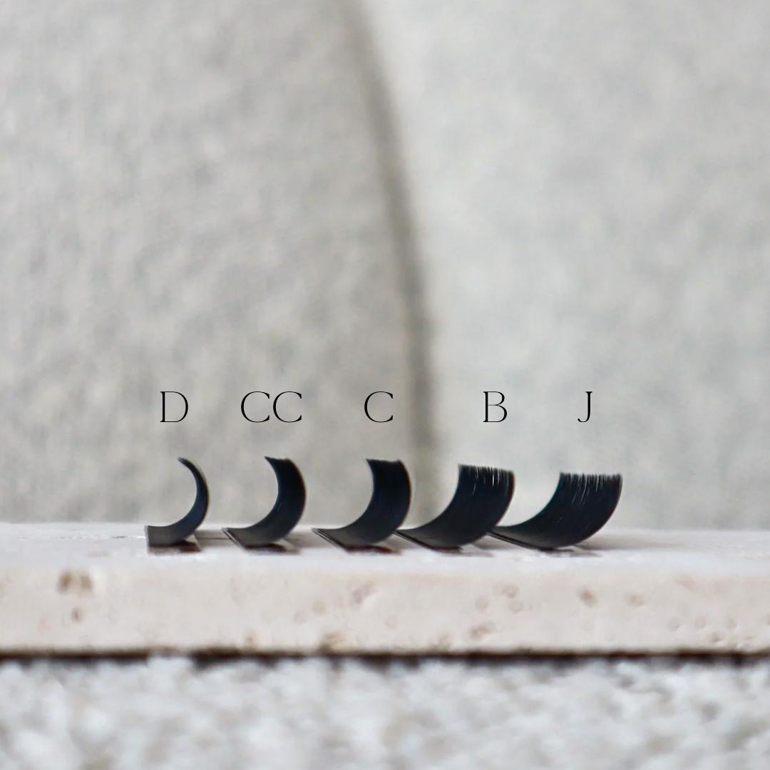 Set of false eyelashes with size labels on a neutral background