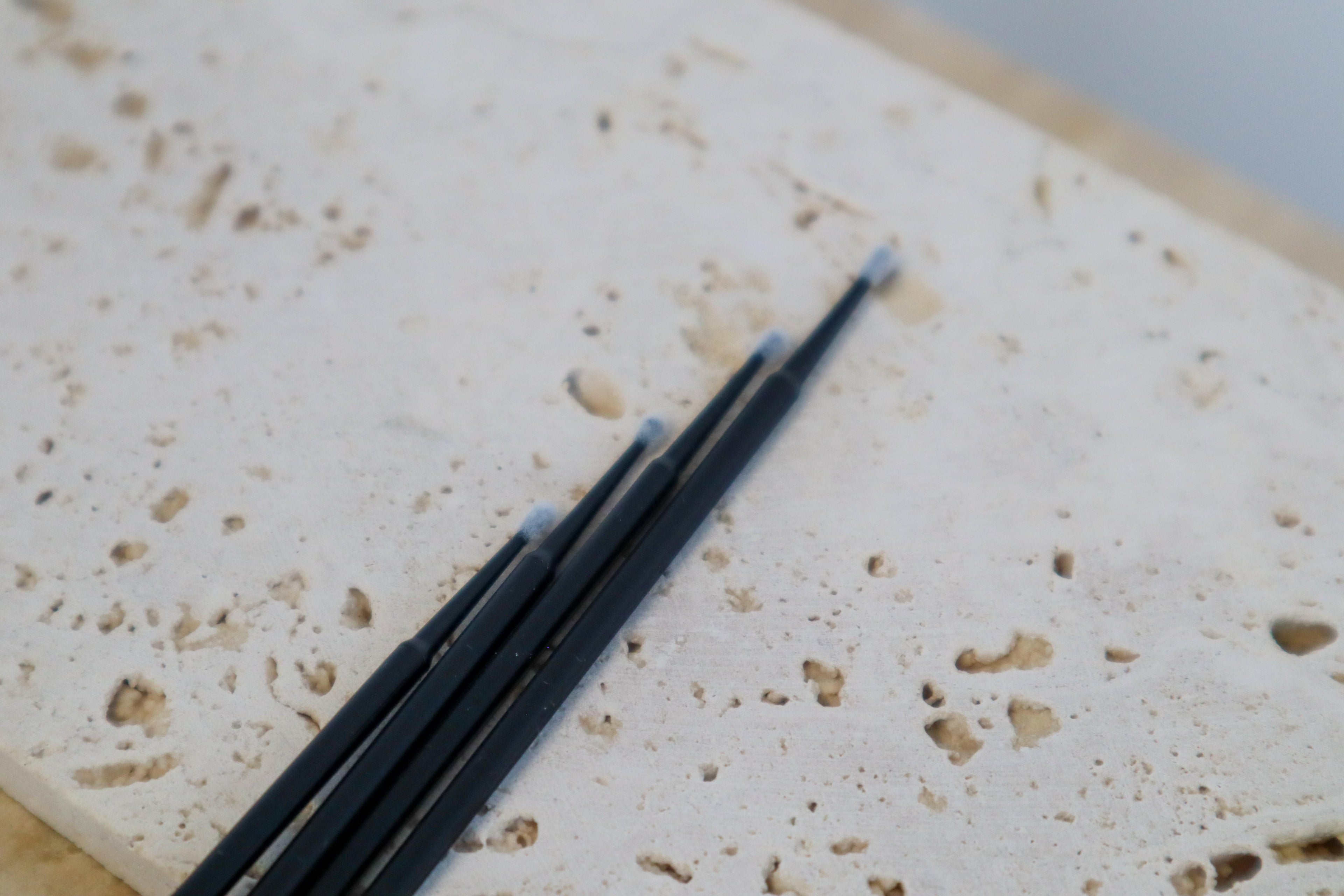 Black micro brushes on a textured white surface