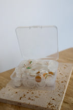Disposable self-adhesive glue flowers in a container on a stone block 