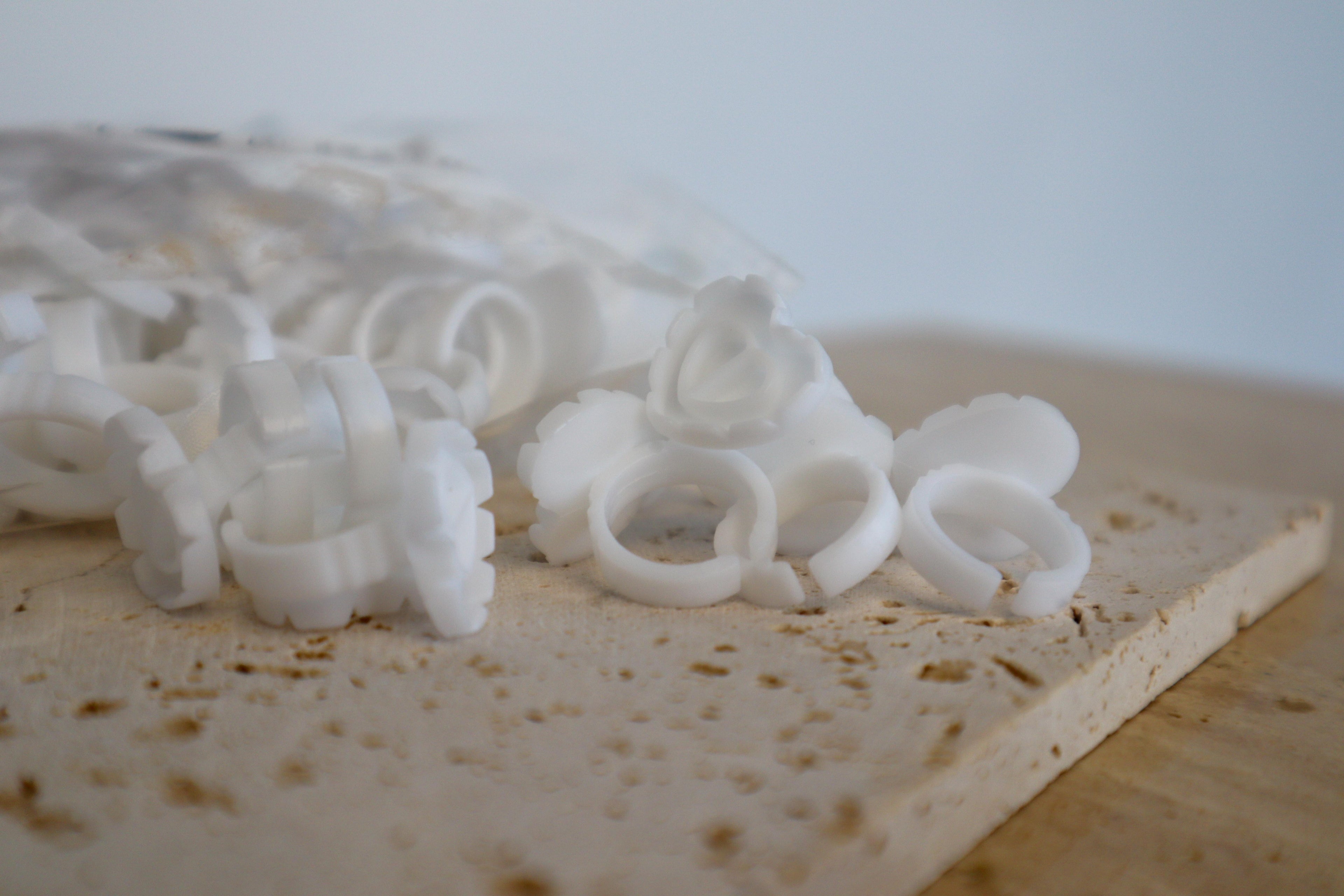 White glue ring holders on a stone slab with a blurred background