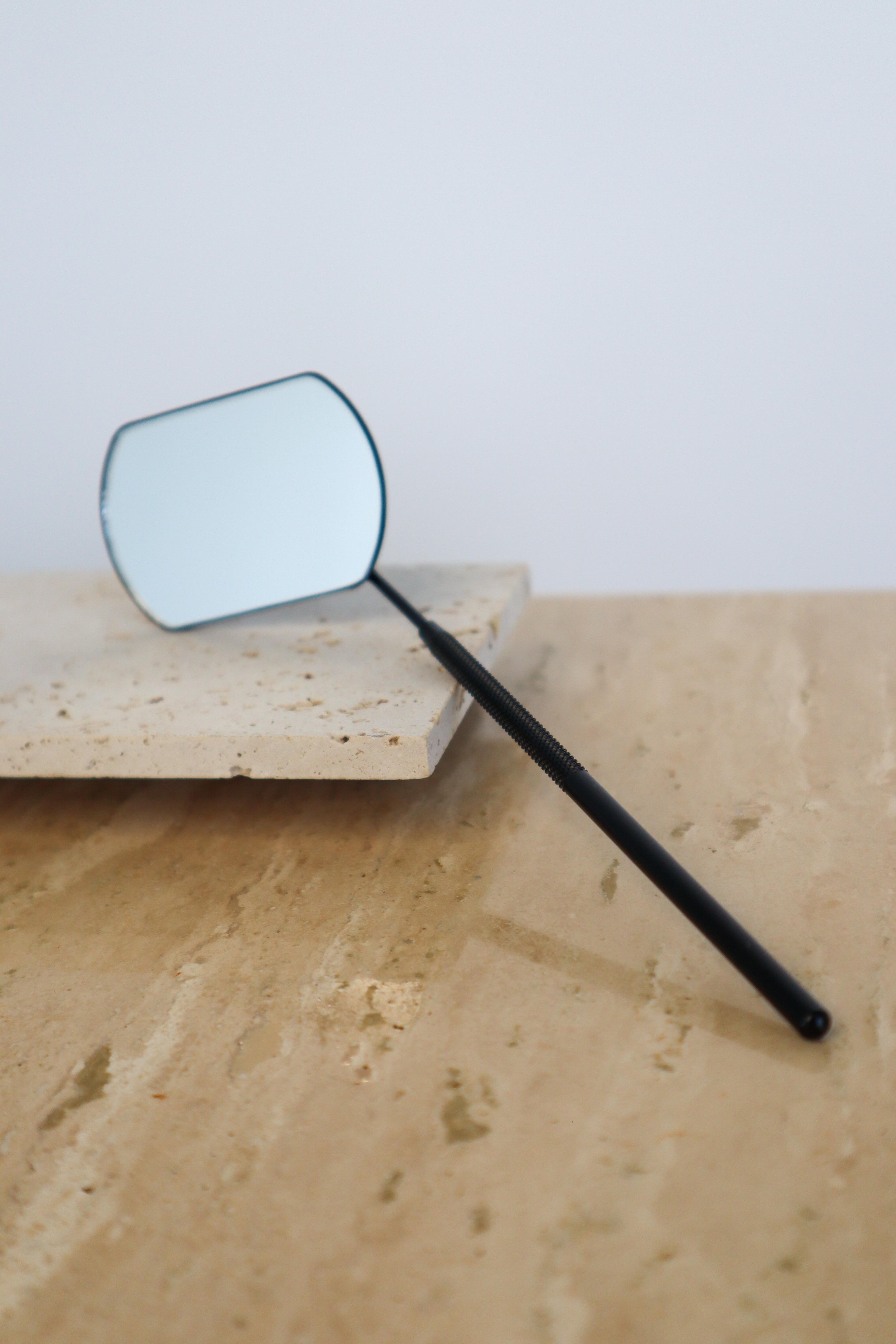 Angled dentist mirror on a neutral surface
