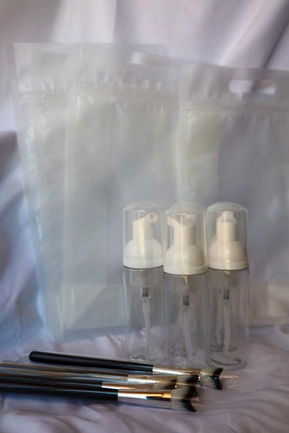Set of white pump bottles with black handles on a white background