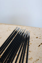 Row of long tip micro brushes on a textured surface with a light background