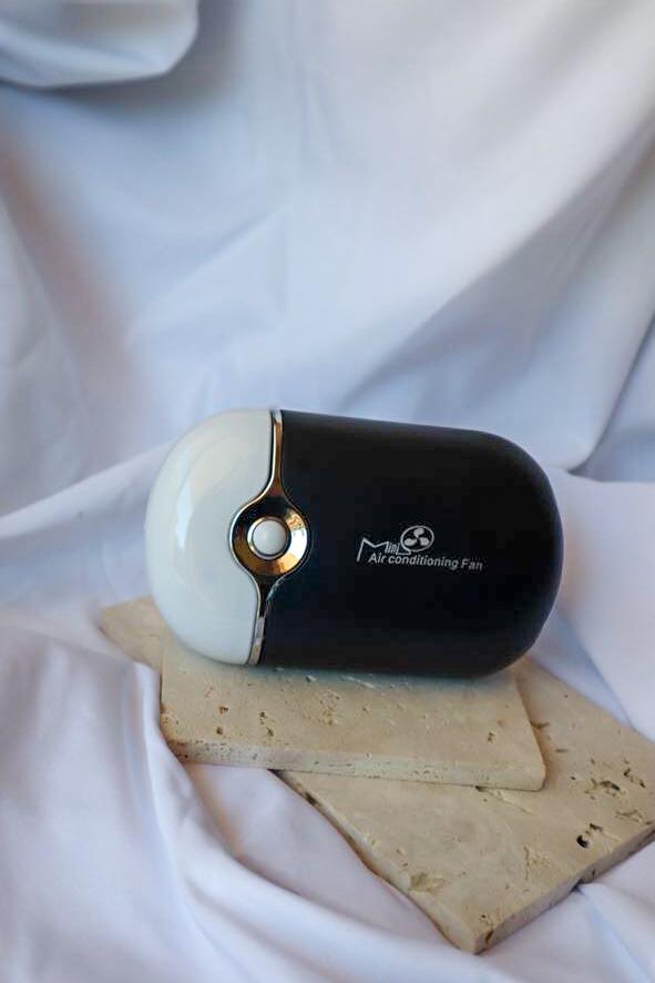 Small air conditioning fan on a white surface
