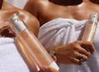 Two skincare bottles held by a person wrapped in a towel, with a focus on the products.