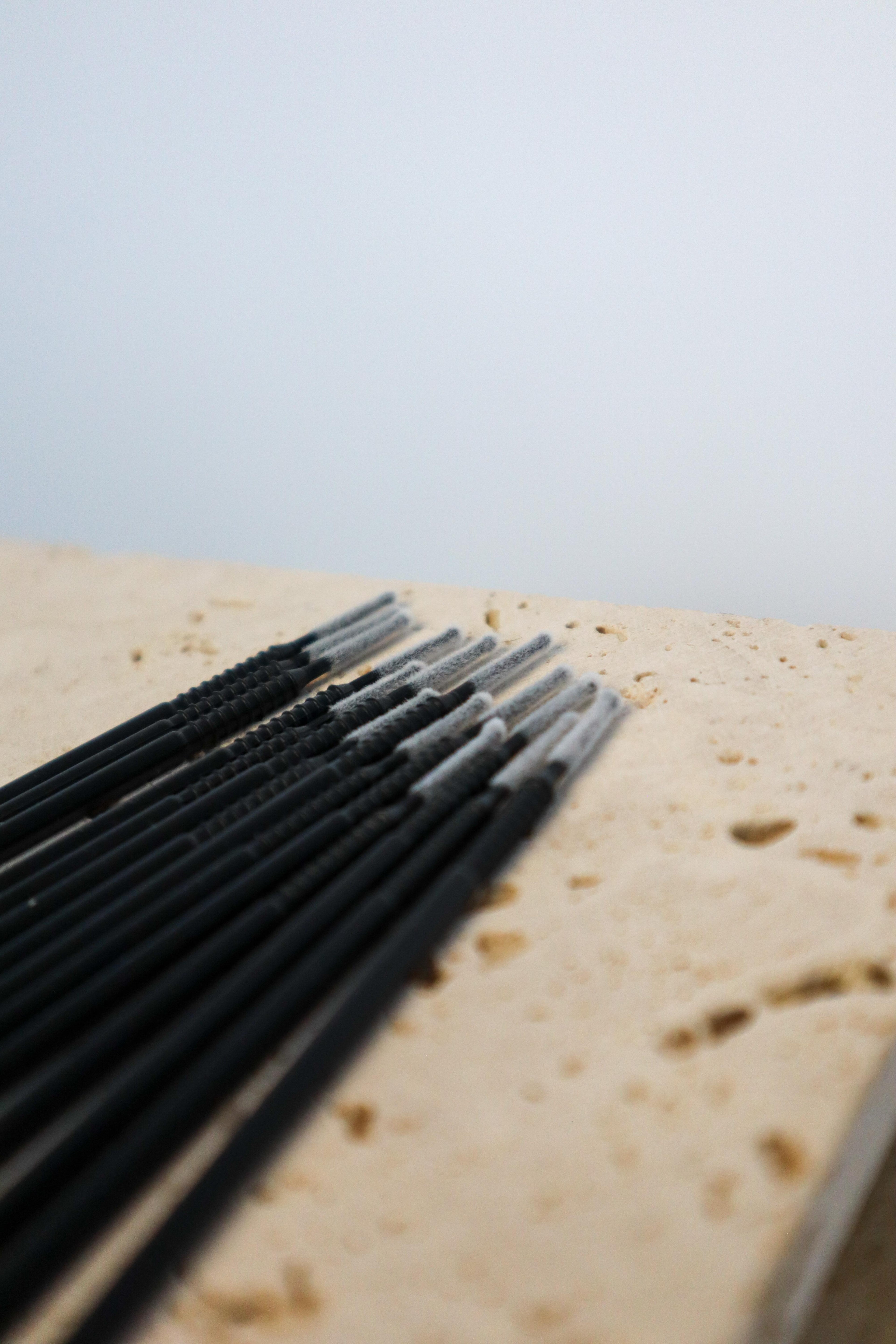 Black long tip micro brushes on a textured surface with a light background