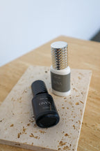 Black and white bottles labeled 'ONYX' and 'LUNA' on a textured surface.