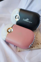 Pink and black handheld fans on a white surface