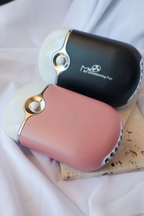 Pink and black handheld fans on a white surface