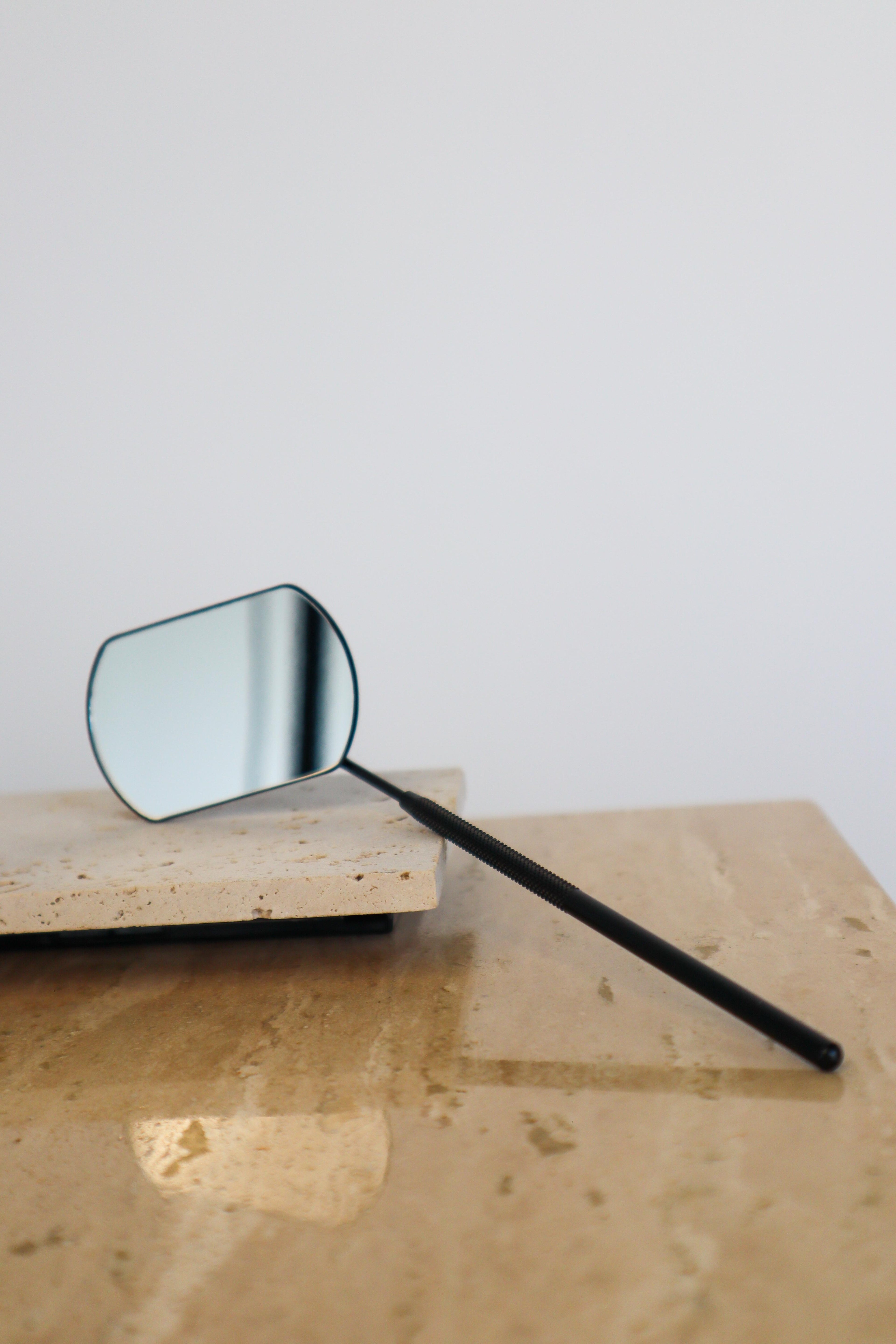 Small mirror on a wooden surface with a plain background