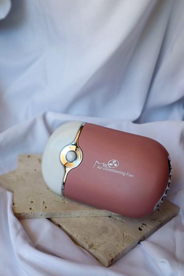 Portable air conditioning fan on a stone surface with a white fabric background
