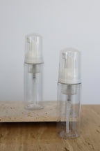 Empty bottles with foaming pump top on neutral background