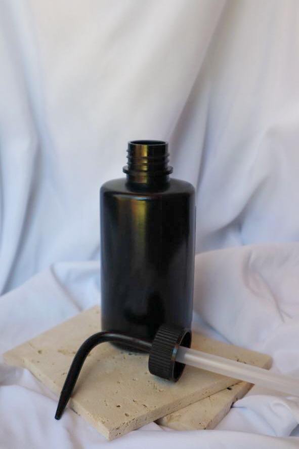 Black bottle with a pump on a white background