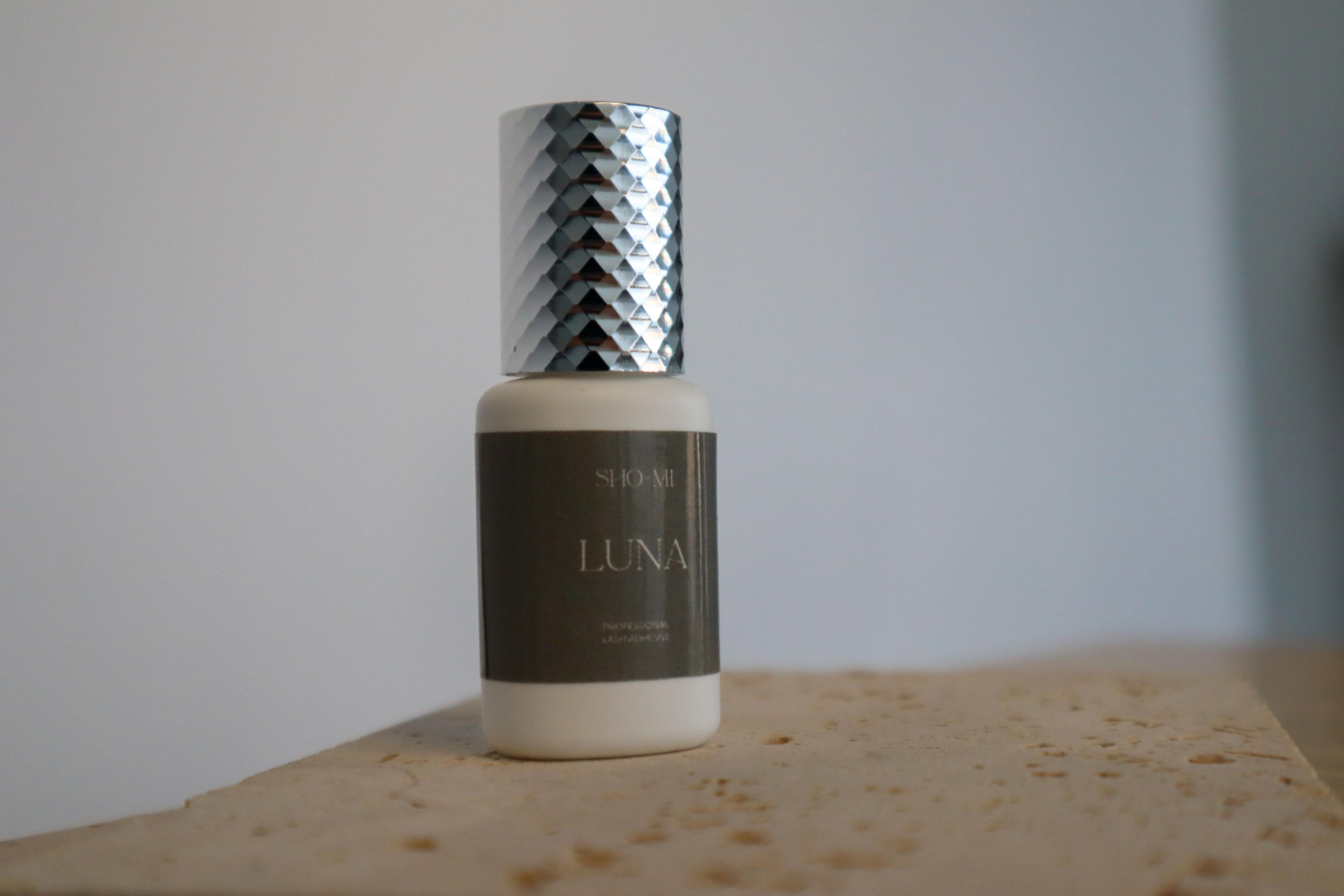 Bottle labeled 'LUNA' with a textured cap on a stone surface