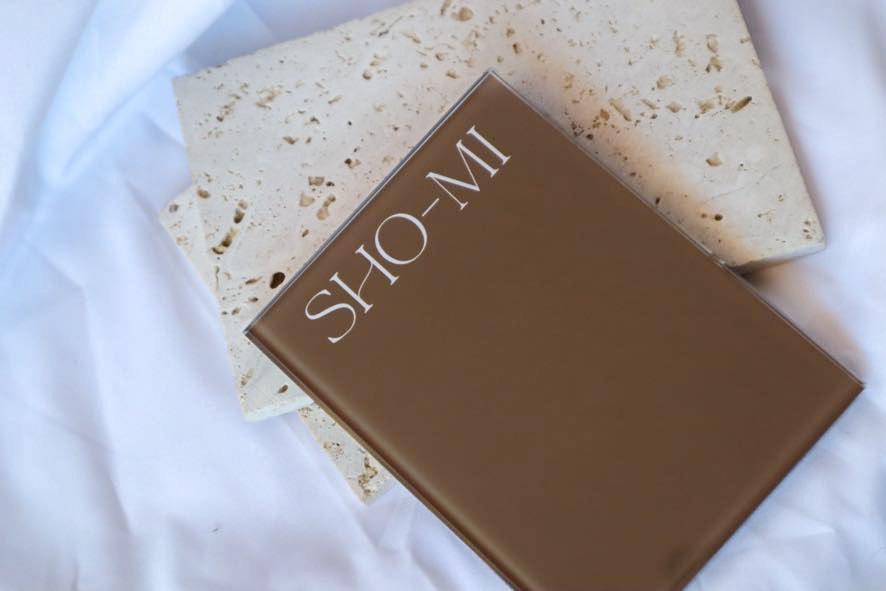 Brown crystal tile with 'SHO-MI' branding on a textured stone surface.