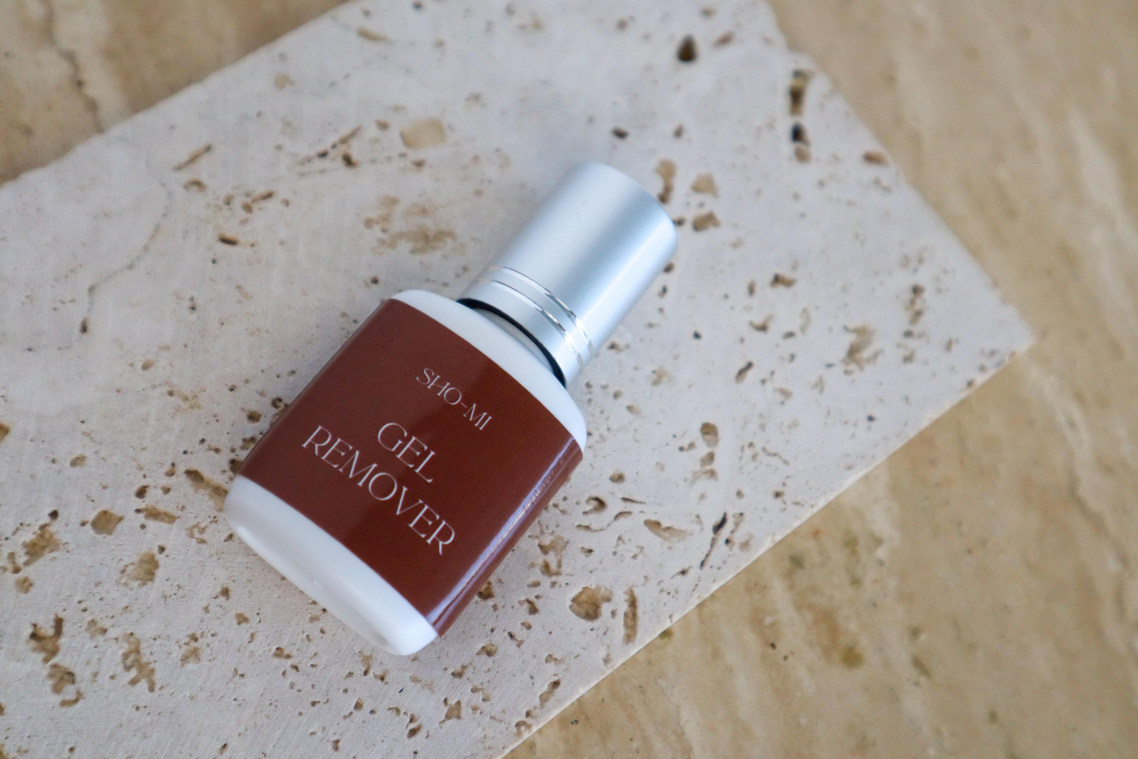 SHO-MI Gel Remover bottle on a textured beige surface